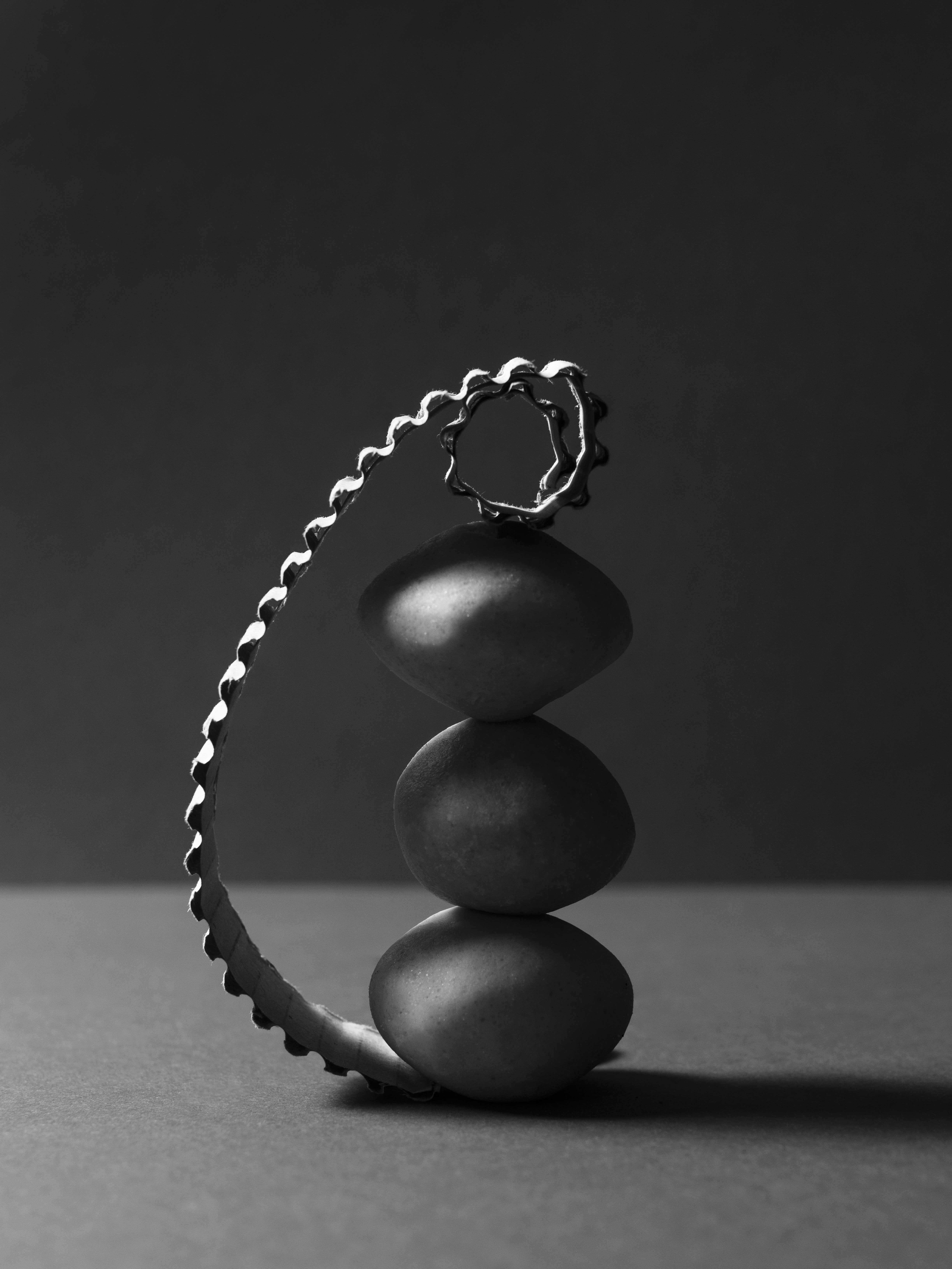 black and white photo of three scoops of soap stacked on top of each other and supported by a cardboard box mounted on the side. 