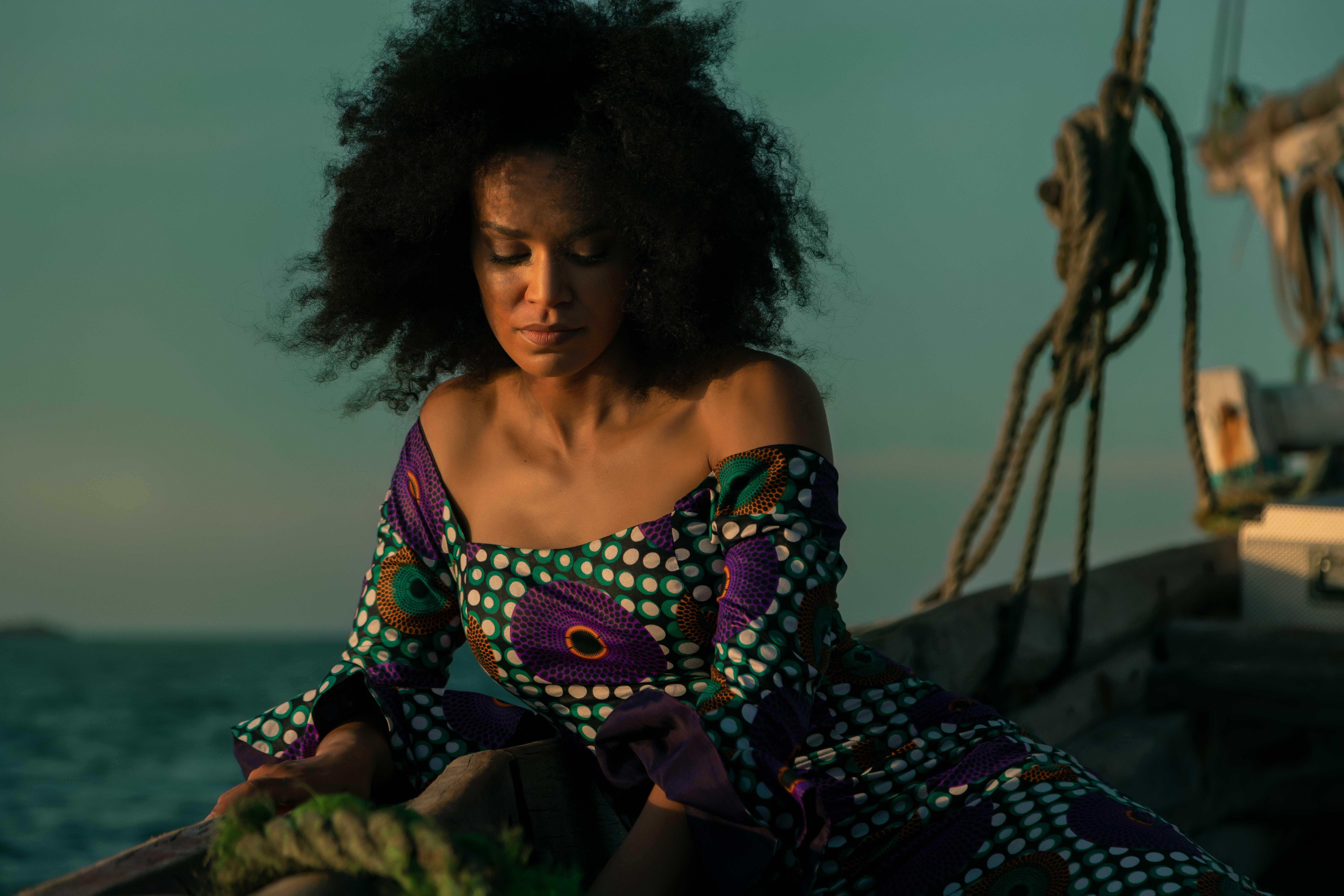 portrait of an african american woman on a boat in a colorful dress.