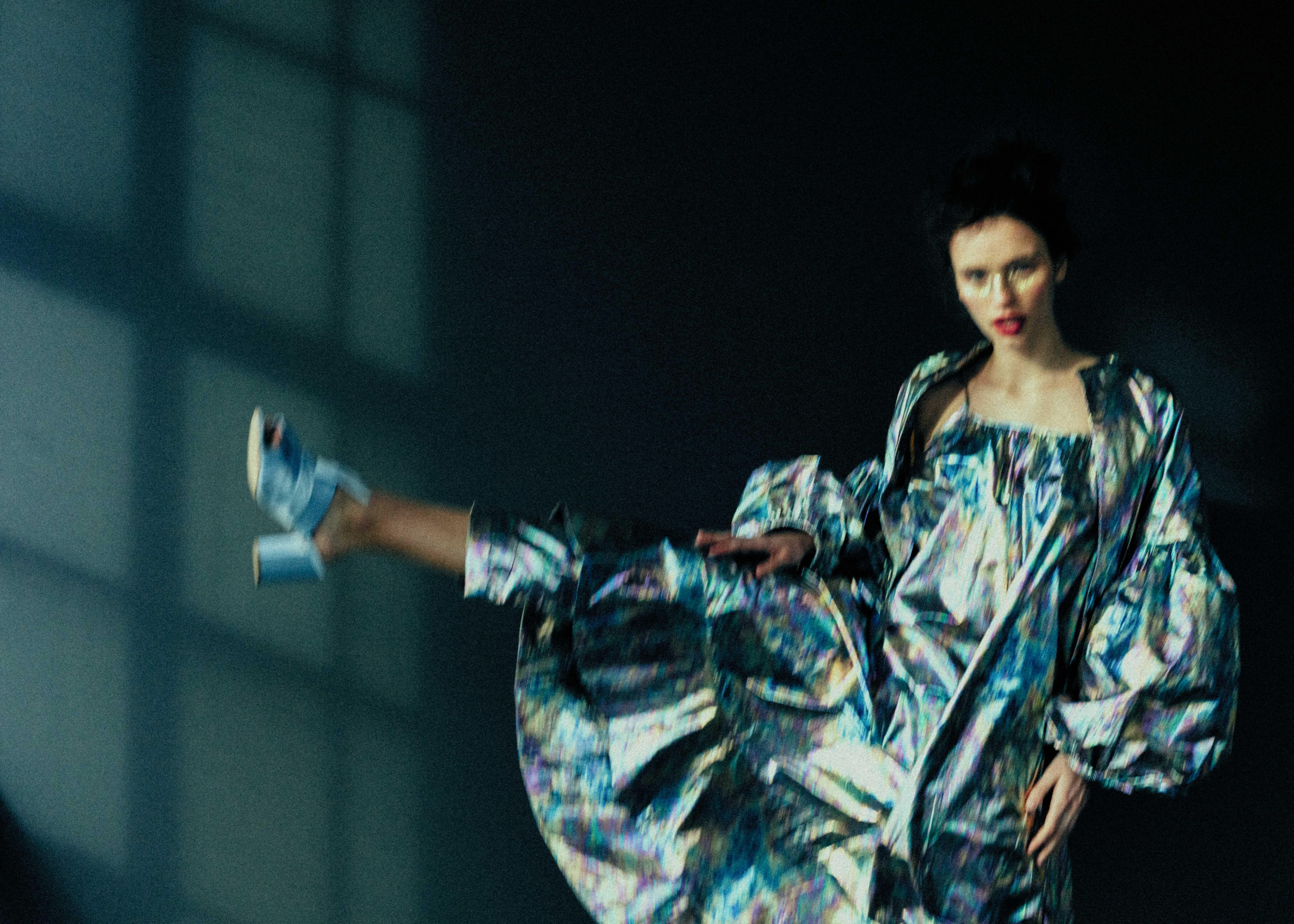 full body shot of a woman in a glittering dress stretching her leg to the side